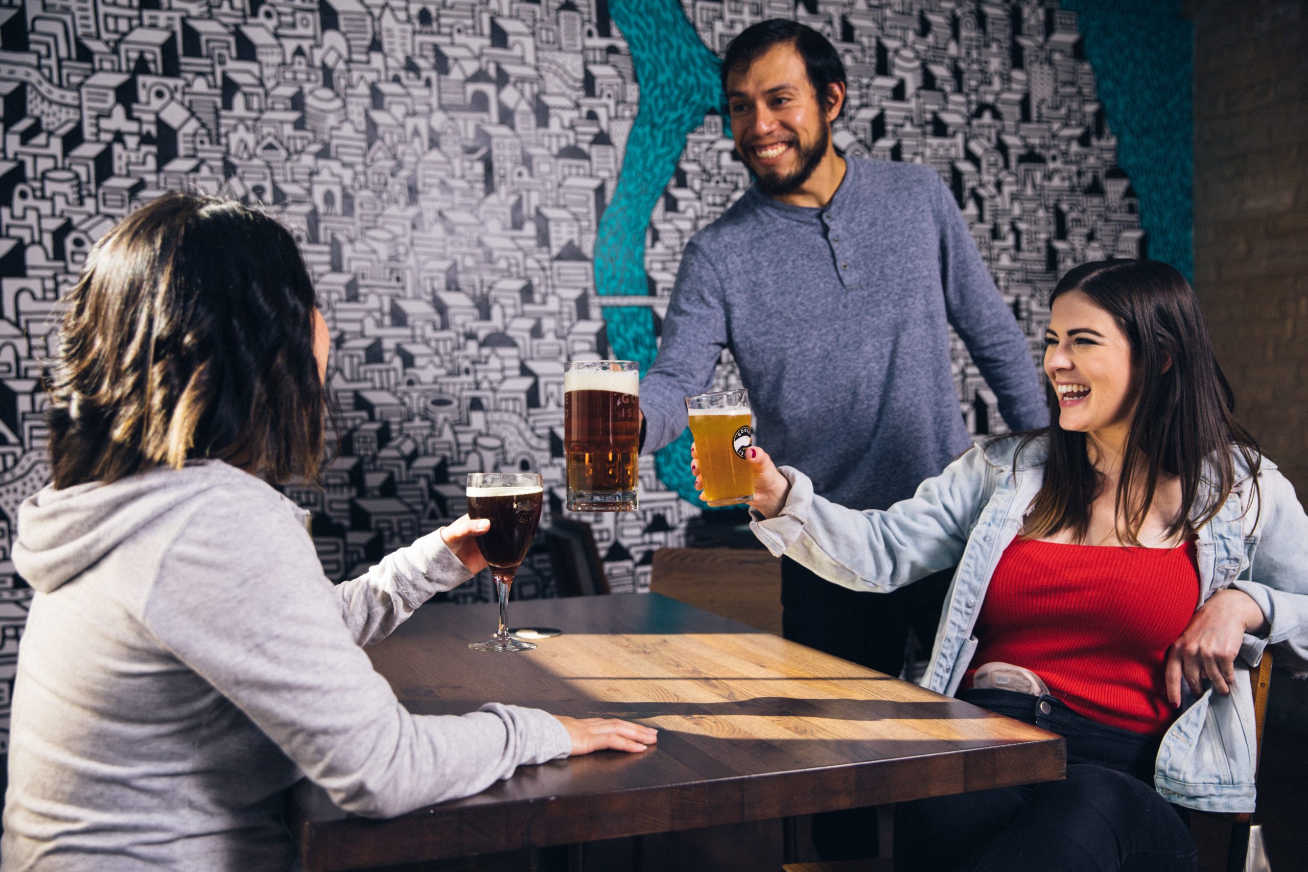 three people raising their glasses of beer